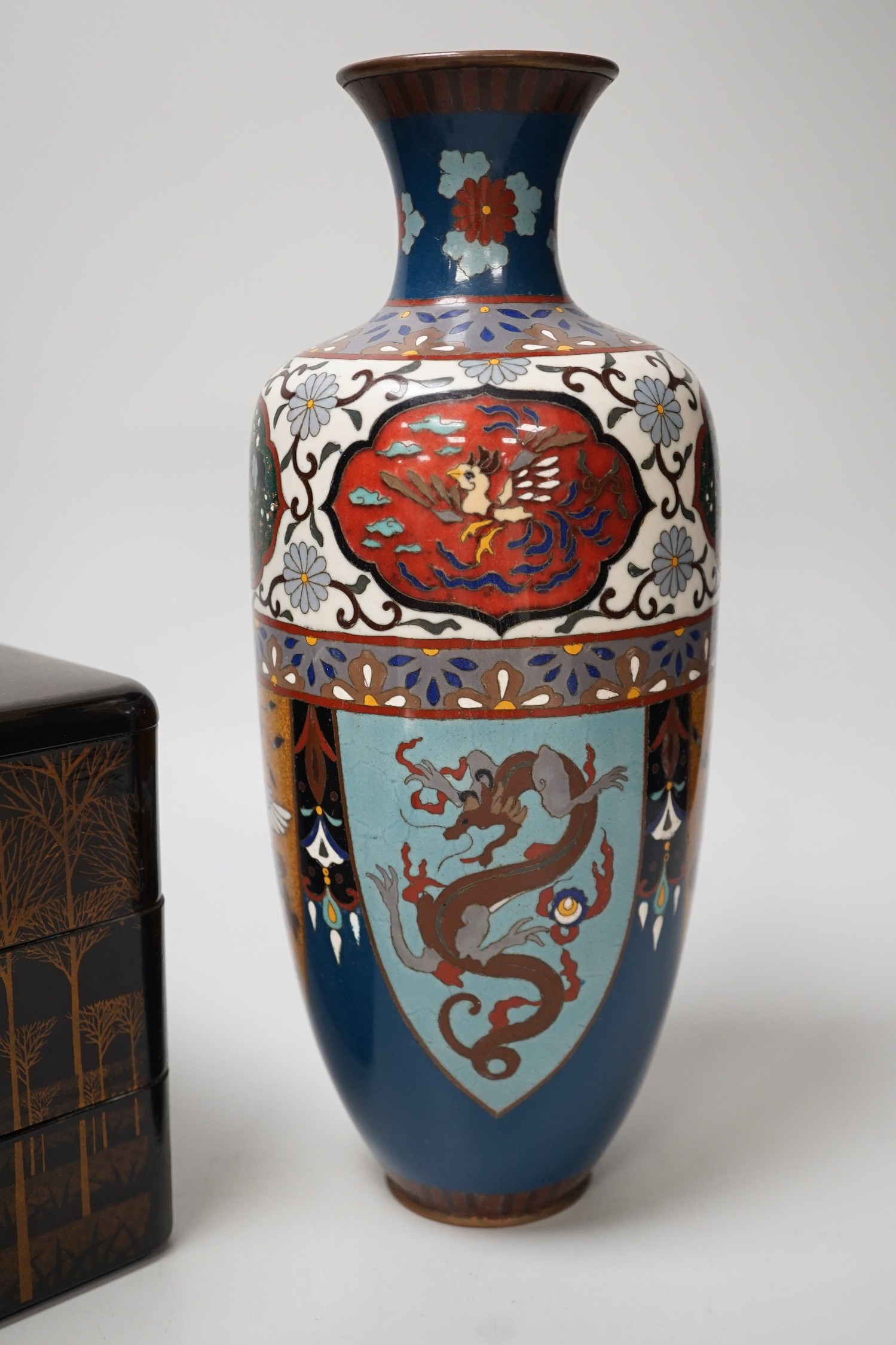 A large Japanese cloisonné enamel vase, 30.5cm high, a similar jar and cover and a Japanese lacquered tiered box with 3-4 drawers. Tree design in gold lacquer.